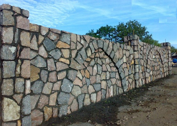 Каменный забор в процессе строительства